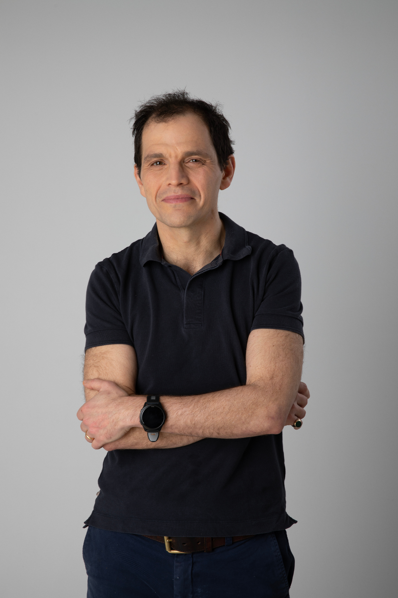Black and white portrait of Daniel Ross, arms folded, looking at the camera.